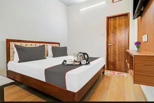 Hotel StudioZ Sahastradhara في دهرادون: غرفة نوم بها سرير عليه صينية طعام