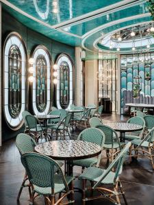a restaurant with tables and chairs and a ceiling at Grand Hyatt Kuwait in Kuwait