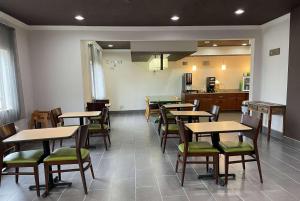 a dining room with tables and chairs and a kitchen at Wingate by Wyndham Marion in Marion