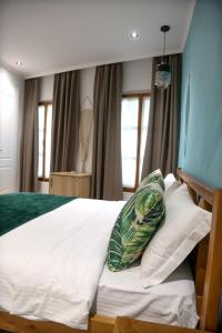 ヴロラにあるAgora Bed & Breakfastのベッドルーム1室(大型ベッド1台、白いシーツ、枕付)