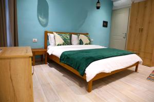 um quarto com uma cama com uma parede azul em Agora Bed & Breakfast em Vlorë