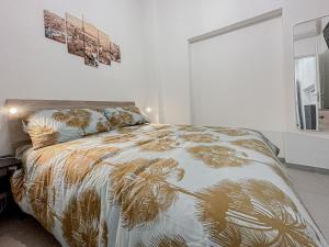 um quarto com uma cama com um edredão dourado e branco em Realkasa Benedetto XIV em Bolonha