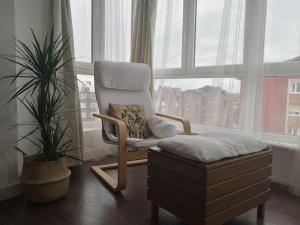 een stoel en poef voor een raam bij Spacious and light flat with beautiful views in Santander
