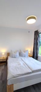 a large white bed in a room with a window at Bungalow Ückeritz in Ueckeritz