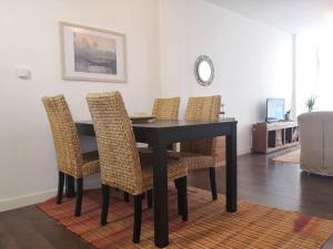 a dining room table with wicker chairs in a living room at Spacious and light flat with beautiful views in Santander