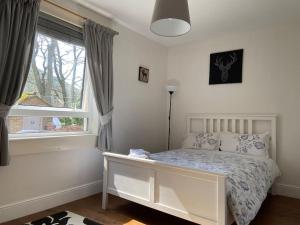 Habitación blanca con cama y ventana en Lovely little house in Yarrowford - Yarrow Valley en Broadmeadows
