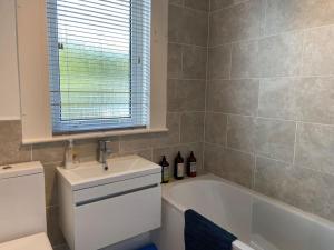 ein Badezimmer mit einem Waschbecken, einer Badewanne und einem WC in der Unterkunft Lovely little house in Yarrowford - Yarrow Valley in Broadmeadows