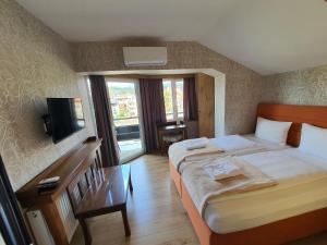 トゥズラにあるSo&sol boutique Hotel, Tuzlaのベッド2台とテレビが備わるホテルルームです。
