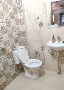 Hotel StudioZ Sahastradhara في دهرادون: حمام مع مرحاض ومغسلة