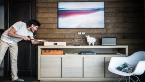 a man standing in front of a table with a box at Appartement Relax in Bourg-Saint-Maurice