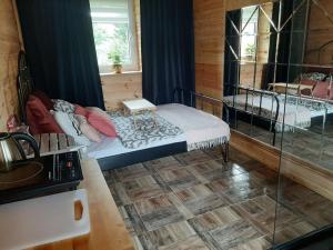 a bedroom with a bed and a glass shower at Domek dla par agroturystyka siedlisko in Paplin