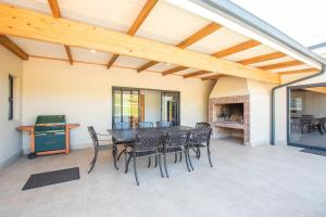 a patio with a table and chairs and a fireplace at Eikenhof Estate in Brackenfell