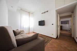 sala de estar con sofá y TV en la pared en Casa Giulia, en Florencia