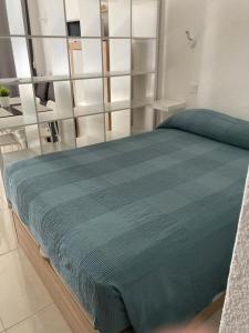 a bedroom with a bed with a blue blanket on it at Tobago508 in Puerto Rico de Gran Canaria