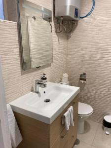a bathroom with a sink and a toilet and a mirror at Tobago508 in Puerto Rico de Gran Canaria