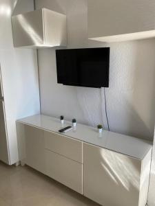 a white cabinet with a flat screen tv on a wall at Tobago508 in Puerto Rico de Gran Canaria