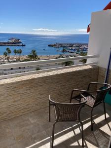 two chairs on a balcony with a view of the beach at Tobago508 in Puerto Rico de Gran Canaria