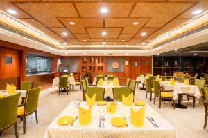 un restaurante con mesas y sillas con servilletas amarillas en Fortune Park Pushpanjali, Durgapur - Member ITC's Hotel Group, en Durgāpur