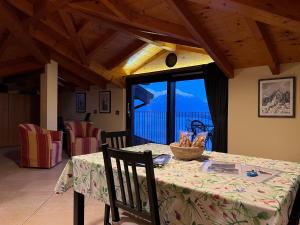 una sala da pranzo con tavolo e balcone di Appartamento Roberta a Musso