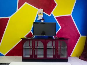 a tv on a table in front of a colorful wall at Nurul Aisyah Homestay in Tanah Rata