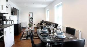 een keuken en een woonkamer met een tafel en stoelen bij Well located Northern Quarter Apartment sleeps Upto 6 in Manchester