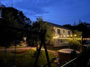 a yard with a swing and a house with lights at Vila Luna Valea Avrigului in Avrig