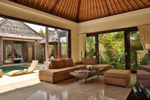 ein Wohnzimmer mit einer Couch und einem Tisch in der Unterkunft Mahagiri Villas Sanur in Sanur