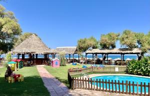 un complejo con piscina, mesas y sillas en Villa Olivia with Pool Vrises Crete, en Alikampos