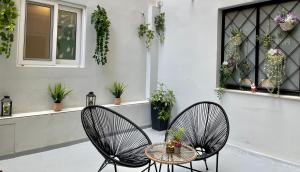 two chairs and a table on a patio with plants at Historic Center Apartment 3 in Athens