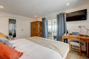 a bedroom with a bed and a desk and a television at Auberge Handfield et Spa in Saint-Marc-sur-Richelieu