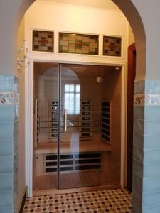 - une porte en verre menant à une cave à vin avec une chambre dans l'établissement Het Domherenhuis, à Heusden-Zolder