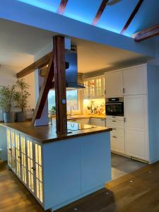 a large kitchen with white cabinets and a blue ceiling at Green Caroline in Berlin