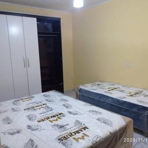 1 dormitorio con 2 camas y armario con faldas en Casa para temporada, en Santa Cruz Cabrália