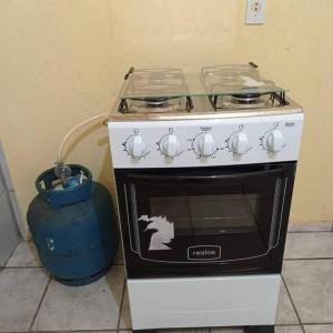 una estufa en blanco y negro con una olla al lado en Casa para temporada, en Santa Cruz Cabrália