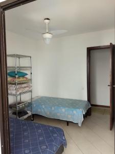 a room with two beds and a door with a shelf at Moderno Apartamento na Enseada com Wi-Fi e Vista Espetacular - Para Família e Home Office - 300m da praia in Guarujá