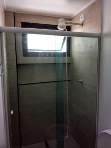 a glass shower door with a window in a bathroom at Moderno Apartamento na Enseada com Wi-Fi e Vista Espetacular - Para Família e Home Office - 300m da praia in Guarujá