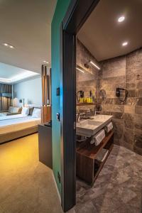 a bathroom with a sink and a bed in a room at HVD Reina del Mar - Premium Spa Service & Free Parking in Obzor