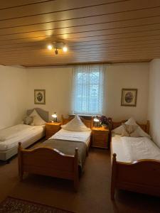 een kamer met 3 bedden en een raam bij Hotel Alt-Lennep in Remscheid