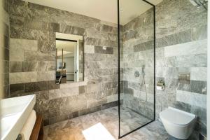 a bathroom with a shower and a toilet and a sink at HVD Reina del Mar - Premium Spa Service & Free Parking in Obzor