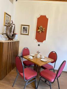 een eetkamer met een tafel en rode stoelen bij Hotel Alt-Lennep in Remscheid