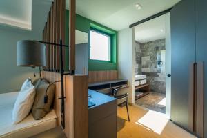a bedroom with a bed and a desk and a bathroom at HVD Reina del Mar - Premium Spa Service & Free Parking in Obzor