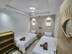 Zimmer mit 2 Betten und einem Spiegel in der Unterkunft Green Surf House in Agadir