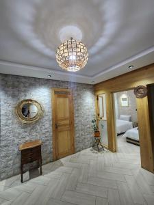 una camera spaziosa con un lampadario a braccio e una camera da letto di Green Surf House ad Agadir
