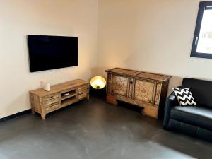 un soggiorno con TV, divano e tavolo di Chalet Charbon a Boltigen