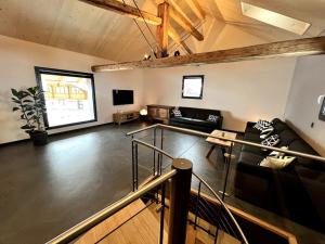 a large living room with a couch and a tv at Chalet Charbon in Boltigen