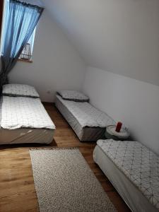 three beds in a room with a window at Agroturystyka Siedlisko 