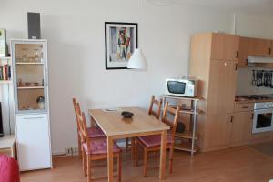 Schönberg in HolsteinにあるFerienappartement K118 in Strandnäheのキッチン(テーブル、椅子付)、キッチン(冷蔵庫付)