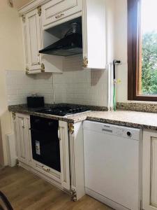 a kitchen with white cabinets and a stove top oven at Kartepe Paradise in Kartepe