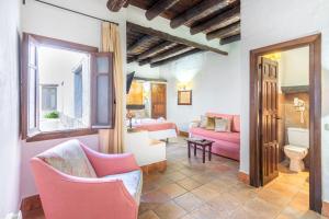 a living room with pink chairs and a couch at Hotel Apartamento Nueva Alcazaba in Busquístar