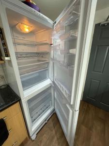 an empty refrigerator with its door open in a kitchen at Lovely Seaside House in Cleethorpes - sleeps 6 in Cleethorpes